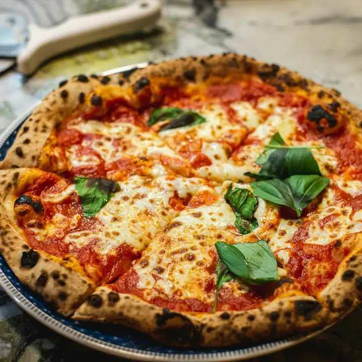 Pizza recém-assada, com a borda inflada e tostada em pontos