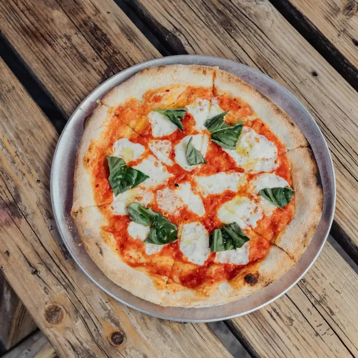 Pizza inteira sobre a tábua de madeira