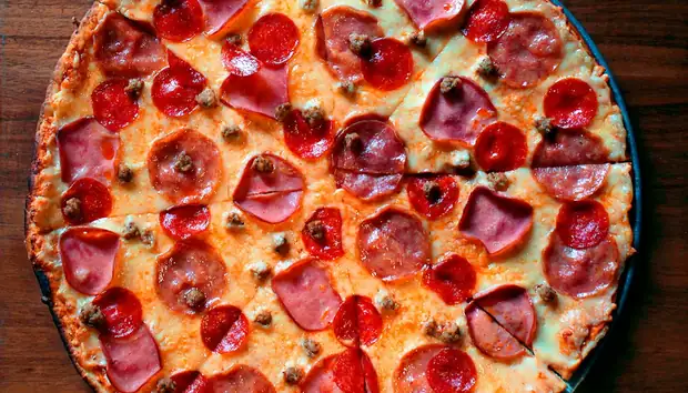 Pizza portuguesa fatiada com presunto e ovo